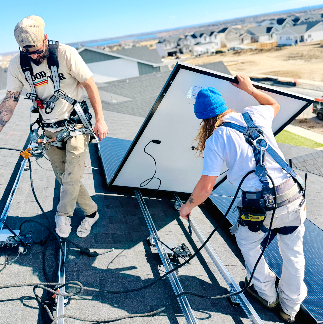 Solar installers mounting a rooftop solar panel
